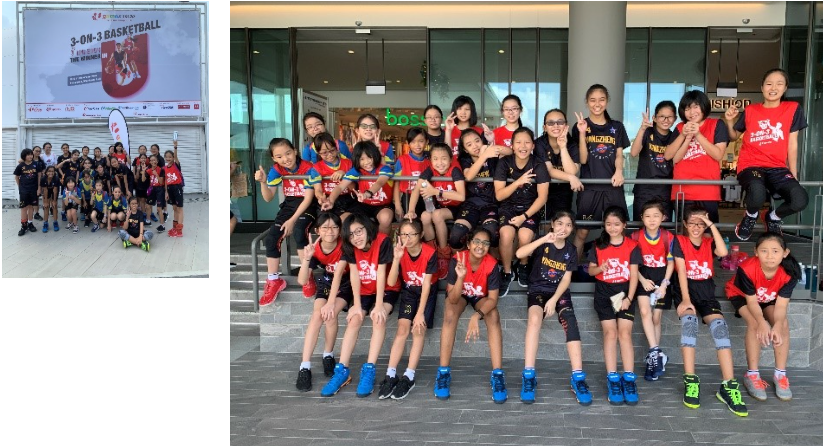 A group of primary school girls basketball players posing at a basketball court with their teachers